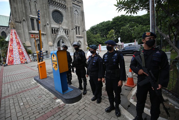 Anggota kepolisian bersama TNI berjaga di depan Gereja Katedral, Jakarta, Jumat (24/12/2021).