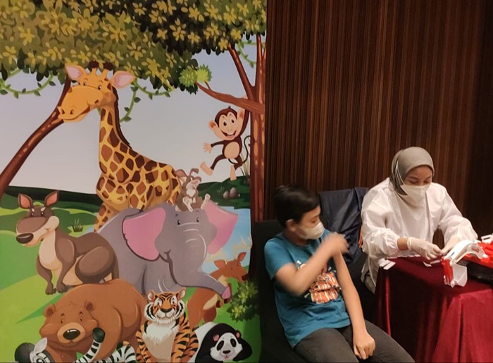 Petugas medis melakukan vaksinasi kepada seorang anak di Jakarta, Kamis (23/12/2021).