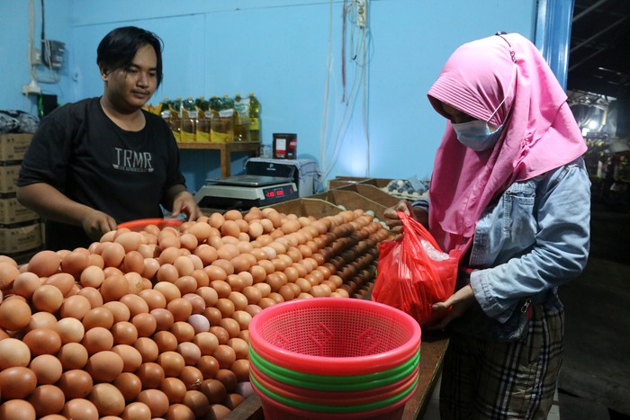 Pedagang telur ayam melayani pedagang di kawasan Jalan Pasar Inpres Serdang, Kemayoran, Jakarta, Sabtu (25/12/2021).
