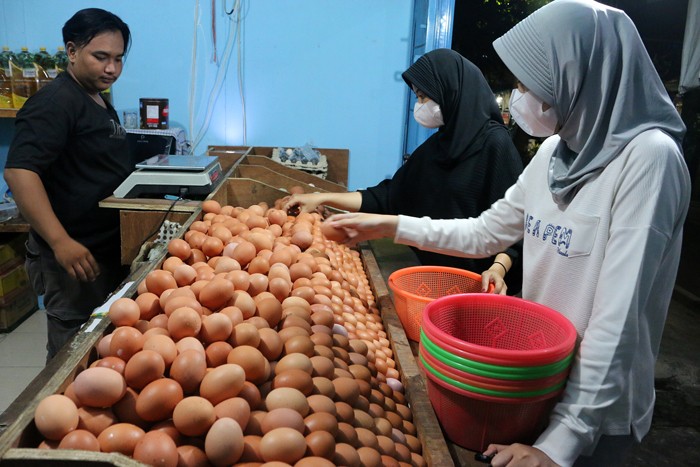 Pedagang telur ayam melayani pedagang di kawasan Jalan Pasar Inpres Serdang, Kemayoran, Jakarta, Sabtu (25/12/2021).
