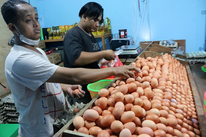 Pedagang telur ayam melayani pedagang di kawasan Jalan Pasar Inpres Serdang, Kemayoran, Jakarta, Sabtu (25/12/2021).