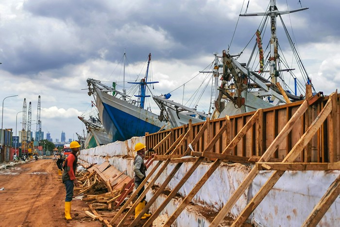 Aktivitas pengerjaan peninggian tanggul kawasan dermaga pelabuhan oleh Pengelola Pelabuhan Sunda Kelapa Jakarta Utara, Minggu (26/12/2021).