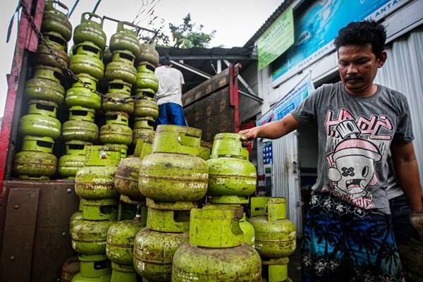 Pekerja saat menurunkan tabung gas ukuran 3 kilogram di agen gas kawasan Lubang Buaya, Jakarta Timur, Rabu (29/12/2021).