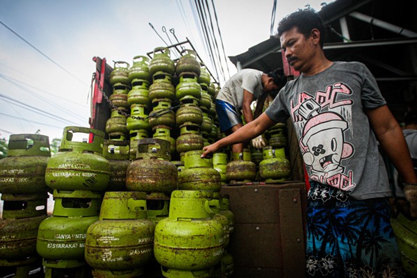 Pekerja saat menurunkan tabung gas ukuran 3 kilogram di agen gas kawasan Lubang Buaya, Jakarta Timur, Rabu (29/12/2021).