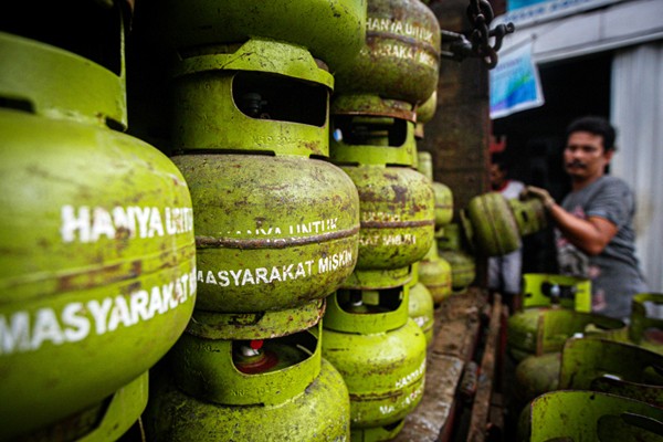 Pekerja saat menurunkan tabung gas ukuran 3 kilogram di agen gas kawasan Lubang Buaya, Jakarta Timur, Rabu (29/12/2021).