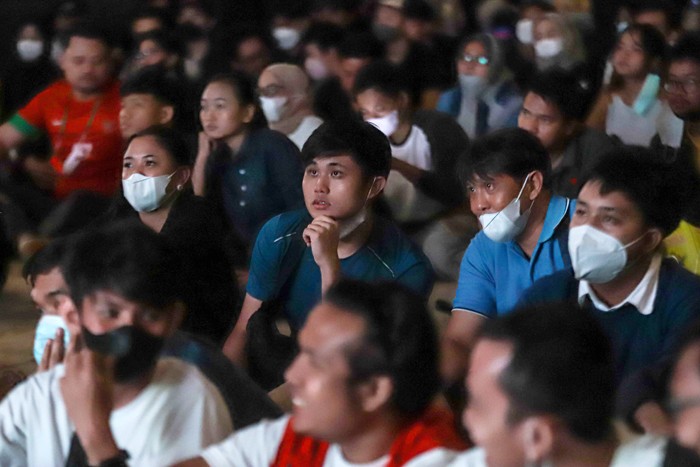 Ekspresi pengunjung saat mengikuti kegiatan nonton bareng (nobar) Final Leg Pertama Piala AFF 2020 di Ruangan Live House, M Bloc Space, Jakarta Selatan.