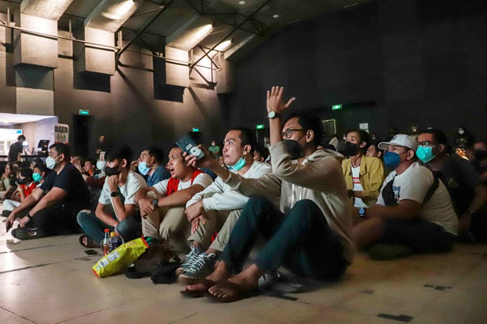 Ekspresi pengunjung saat mengikuti kegiatan nonton bareng (nobar) Final Leg Pertama Piala AFF 2020 di Ruangan Live House, M Bloc Space, Jakarta Selatan.