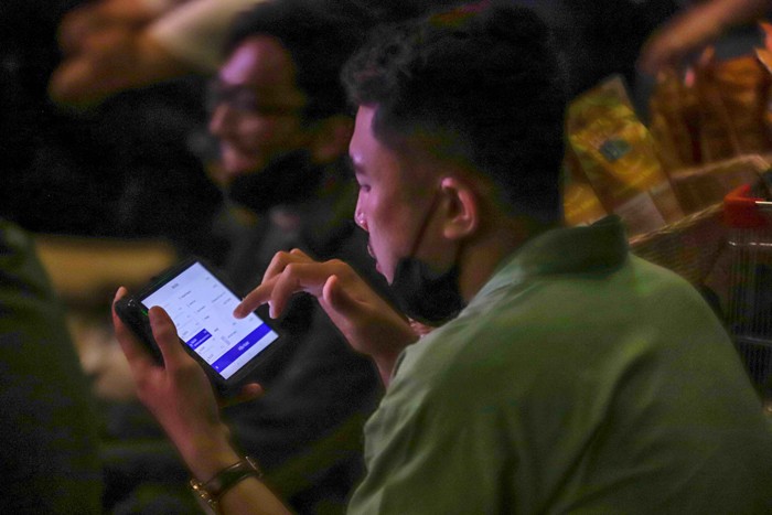 Ekspresi pengunjung saat mengikuti kegiatan nonton bareng (nobar) Final Leg Pertama Piala AFF 2020 di Ruangan Live House, M Bloc Space, Jakarta Selatan.