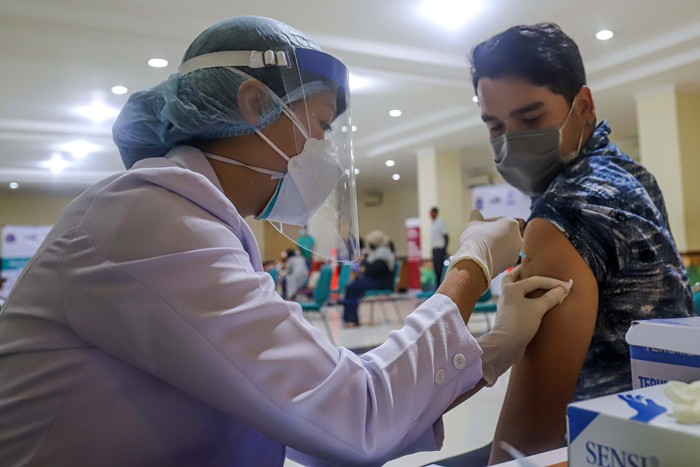 Petugas kesehatan menyuntikkan vaksin Covid-19 kepada Warga Negara Asing (WNA) di Gelanggang Remaja Tanjung Priok, Jakarta Utara, Rabu (29/12/2021).