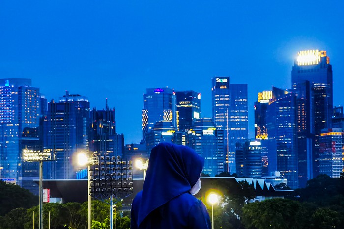 Pengunjung melihat deretan gedung bertingkat dari Skywalk Senayan Park, di Jakarta, Rabu (29/12/2021).