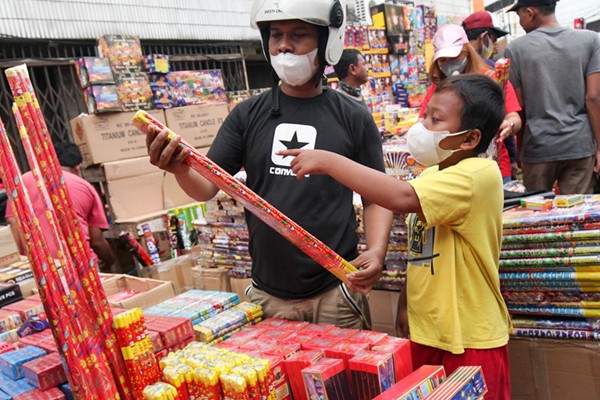 Warga berburu kembang api jelang perayaan malam tahun baru 2022 di Pasar Asemka, Jakarta Barat, Kamis (30/12/2021).