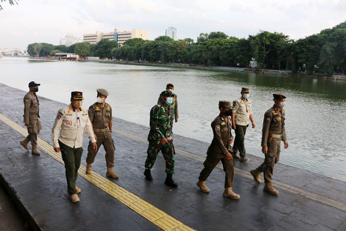 Petugas Satpol PP berjaga di kawasan Danau sunter yang ditutup di Jakarta Utara, Jumat (31/12/2021).