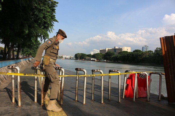 Petugas Satpol PP berjaga di kawasan Danau sunter yang ditutup di Jakarta Utara, Jumat (31/12/2021).