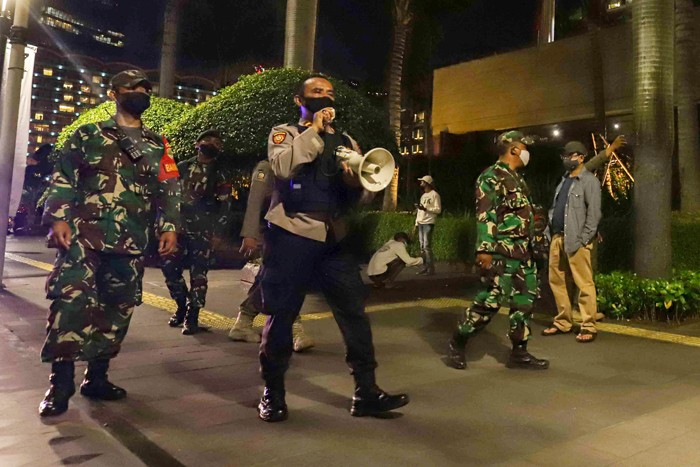 Petugas gabungan membubarkan kerumunan warga saat pemberlakukan Crowd Free Night di Kawasan Bundaran HI, Jakarta Pusat, Jumat (31/12/2021).