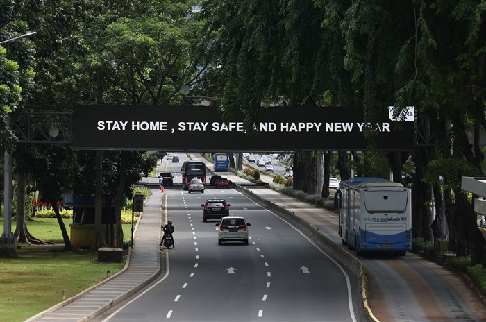 Sejumlah kendaraan melintasi di Jalan Sudirman, Jakarta, Sabtu (1/1/2022).