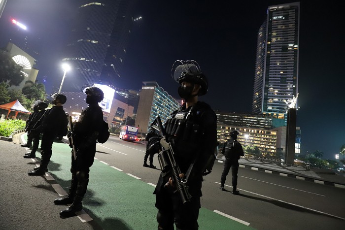 Sejumlah personel Satbrimob Polda Metro Jaya berjaga saat pemberlakuan Crowd Free Night di Bundaran Hotel Indonesia, Jakarta, Jumat (31/12/2021).