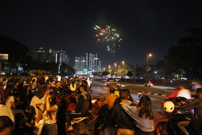 Warga merayakan malam pergantian tahun baru di kawasan flayover Kemayoran, Jakarta, Sabtu (1/1/2022).