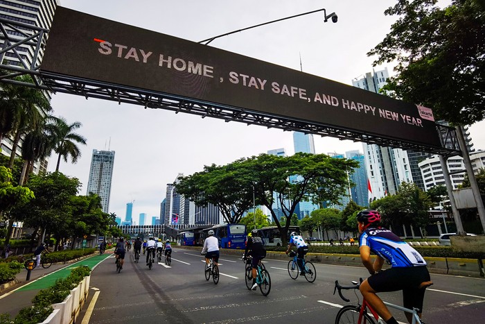 Aktivitas warga saat berolahraga pada minggu pertama tahun baru 2022 di Jalan Sudirman, Jakarta Pusat, Minggu (2/1/2022).