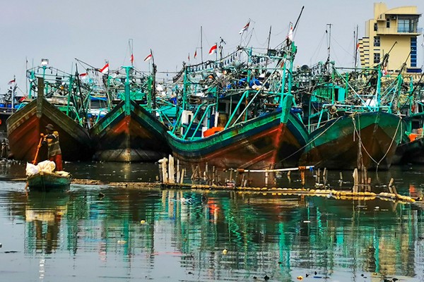 Warga menggunakan perahu kecil mencari barang-barang yang dapat dijual di Muara Angke, Jakarta Utara, Senin (3/1/2022).