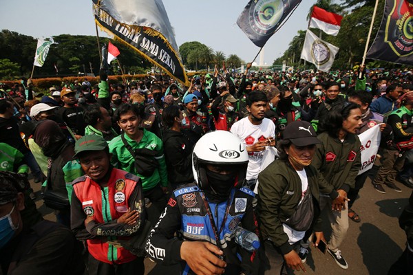 Sejumlah pengemudi ojek online membentangkan spanduk saat aksi unjuk rasa di Jakarta, Rabu (5/1/2022).