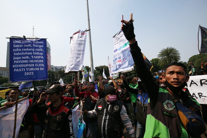 Sejumlah pengemudi ojek online membentangkan spanduk saat aksi unjuk rasa di Jakarta, Rabu (5/1/2022).