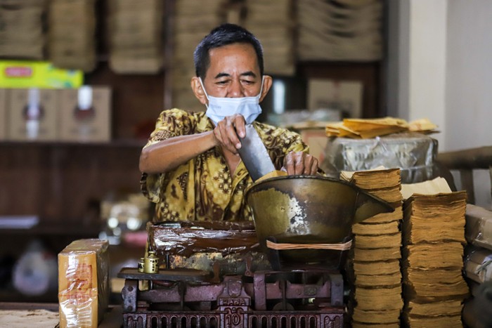 Sejumlah pekerja menggiling dan membungkus kopi di Toko Kopi Sari Murni, Jatinegara, Jakarta Timur, Kamis (6/1/2022).