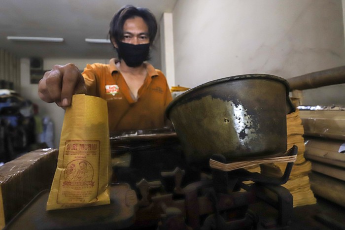 Sejumlah pekerja menggiling dan membungkus kopi di Toko Kopi Sari Murni, Jatinegara, Jakarta Timur, Kamis (6/1/2022).