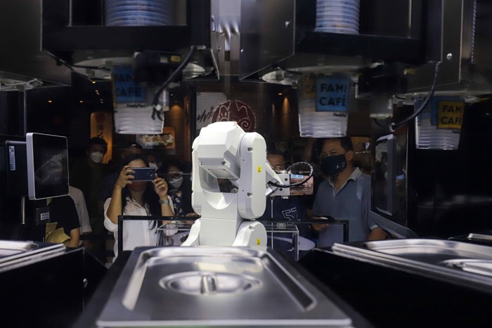 Sejumlah pengunjung menyaksikan sebuah robot barista yang membuat minuman kopi di salah satu toko ritel, Grand Indonesia, Jakarta Pusat, Sabtu (8/1/2022).