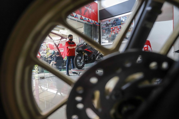 Petugas membersihkan sepeda motor yang di panjang di salah satu dealer motor di kawasan Pasar Minggu, Jakarta Selatan, Senin (10/1/2022).
