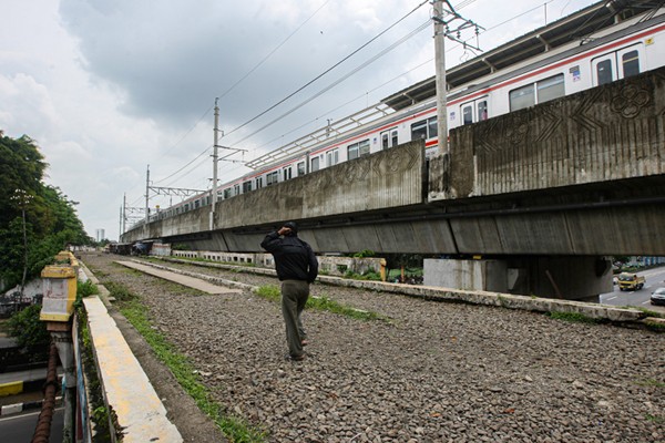 Warga berjalan diatas jembatan kereta api di kawasan Matraman, Jakarta Timur, Kamis (13/1/2022).