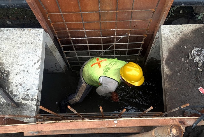 Sejumlah pekerja melakukan perbaikan drainase dan gorong-gorong di kawasan Semarang Utara, Jawa Tengah, Jumat (14/1/2022).
