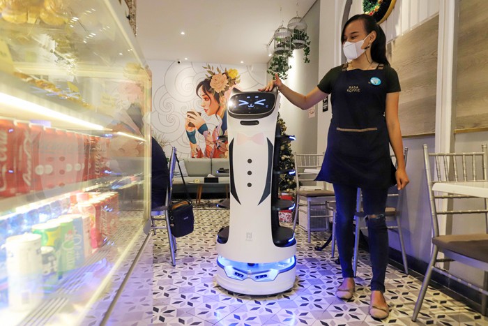 Pekerja mengoperasikan robot pramusaji bernama Kitty di Rasa Koffie di kawasan Pasar Baru, Jakarta Pusat, Jumat (14/1/2022).