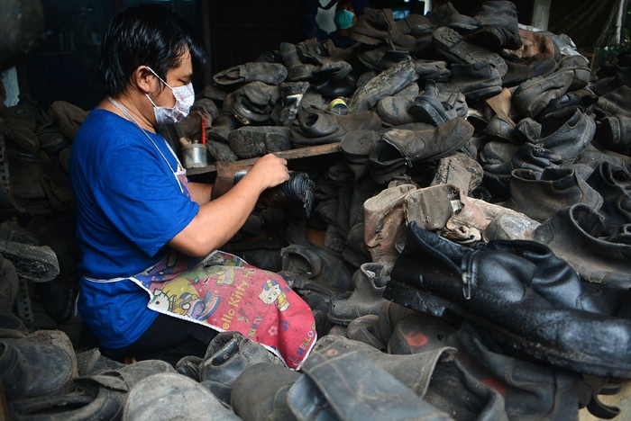 Warga merestorasi limbah sepatu proyek yang akan dijual kembali di kawasan Gunung Sindur, Bogor, Sabtu (15/1/2022).