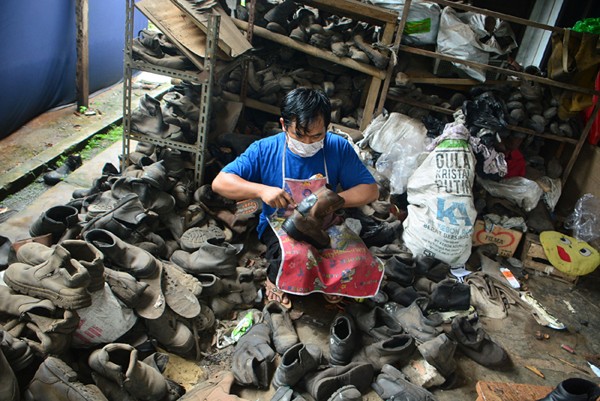 Warga merestorasi limbah sepatu proyek yang akan dijual kembali di kawasan Gunung Sindur, Bogor, Sabtu (15/1/2022).