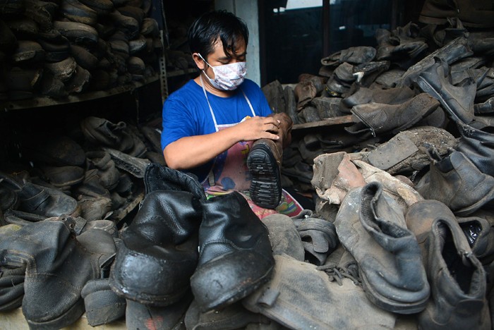 Warga merestorasi limbah sepatu proyek yang akan dijual kembali di kawasan Gunung Sindur, Bogor, Sabtu (15/1/2022).