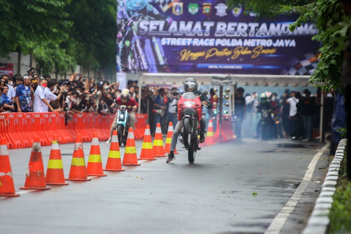 Aksi para pembalap liar saat beradu cepat di ajang Street Race Polda Metro Jaya di Jalan Inspeksi Kali Ancol, Jakarta Utara, Minggu (16/1/2022).