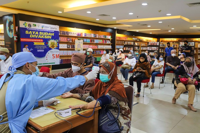 Vaksinator menyuntikkan vaksin Covid-19 dosis ketiga (booster) di Toko Buku Gramedia, Matraman, Jakarta Timur, Senin (17/1/2022).