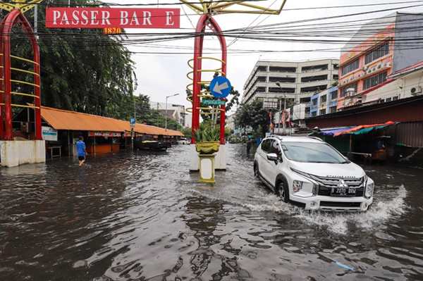 Warga mendorong sepeda motor yang mogok akibat terendam banjir di ruas Jalan Gereja Ayam, Pasar Baru, Jakarta Pusat, Selasa (18/1/2022).