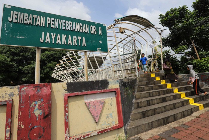 Sejumlah warga melintas di Jembatan Penyeberangan Orang (JPO) Jayakarta di Kawasan Menteng, Jakarta Pusat, Rabu (19/1/2022).