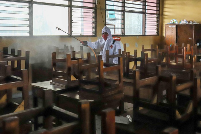 Petugas Palang Merah Indonesia (PMI) melakukan penyemprotan disinfektan pada ruang laboratorium di SMP Negeri 43, Jakarta Selatan, Kamis (20/1/2022).
