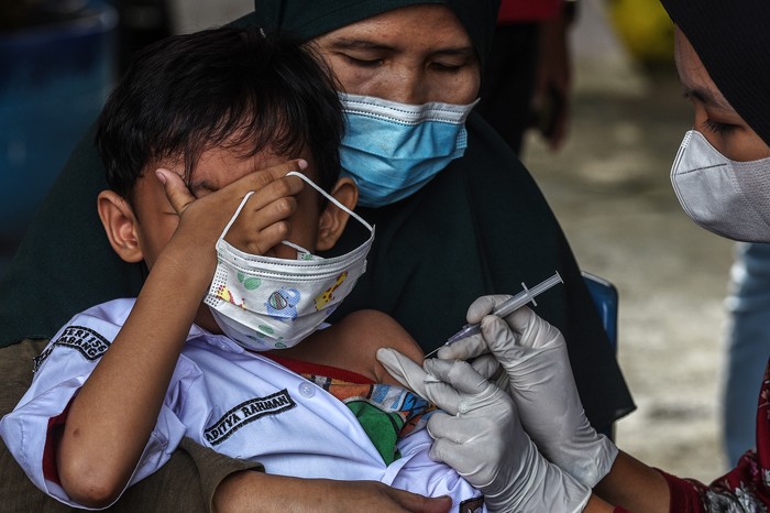 Petugas Polsekta Kemuning bersama petugas puskesmas melakukan vaksinasi Covid-19 ke murid SD Negeri 156.