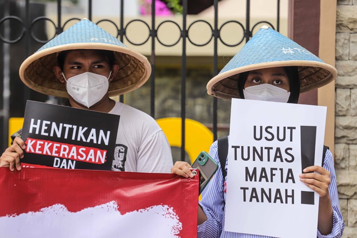 Sejumlah peserta aksi unjuk rasa mengenakan topi caping berdiri di depan gedung Mabes Polri, Jakarta Selatan, Jumat (21/1/2022).