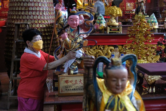 Pengurus Klenteng mendandani Rupang setelah dimandikan di Klenteng Xian Ma, Makssar, Minggu (23/1/2022).