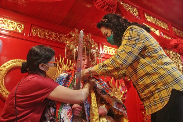 Pengurus Klenteng mendandani Rupang setelah dimandikan di Klenteng Xian Ma, Makssar, Minggu (23/1/2022).