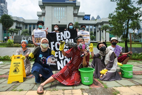 Sejumlah aktivis lingkungan hidup yang tergabung dalam komunitas Jeda Untuk Iklim menggelar aksi bersih-bersih di depan Plaza Mandiri, Jakarta.