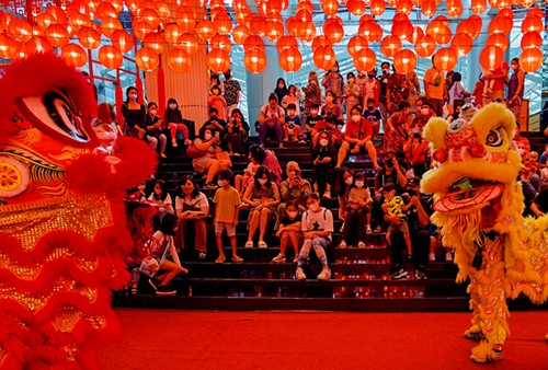 Anak-anak dan sejumlah pengunjung memberikan angpao kepada barongsai untuk menyambut perayaan Imlek di pusat perbelanjaan, Jakarta Barat, Minggu (30/1/2022).
