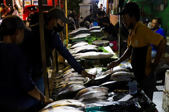 Pedagang ikan bandeng saat melayani pembeli untuk disajikan sebagai hidangan khas saat Hari Raya Imlek di Jakarta Barat, Minggu (30/1/2022).