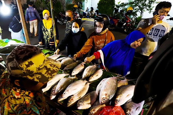 Pedagang ikan bandeng saat melayani pembeli untuk disajikan sebagai hidangan khas saat Hari Raya Imlek di Jakarta Barat, Minggu (30/1/2022).