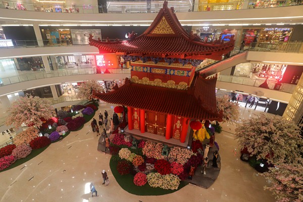 Warga berswafoto dengan latar belakang hiasan Pagoda di salah satu pusat perbelanjaan di Jakarta Pusat, Senin (31/1/2022).