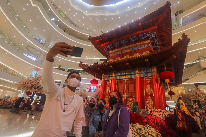 Warga berswafoto dengan latar belakang hiasan Pagoda di salah satu pusat perbelanjaan di Jakarta Pusat, Senin (31/1/2022).